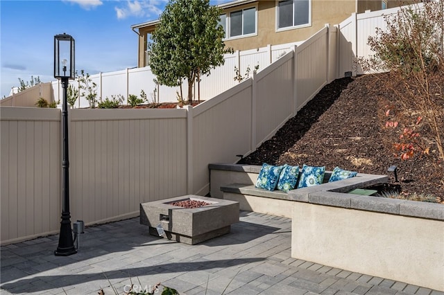 view of patio with an outdoor fire pit and a fenced backyard