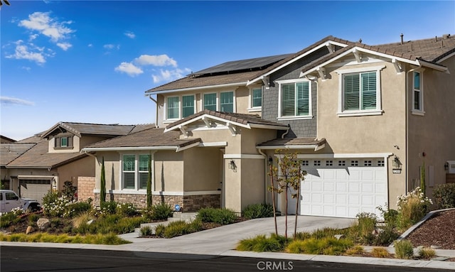 view of front of property with solar panels, stucco siding, a garage, stone siding, and driveway