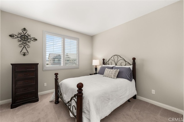 bedroom with baseboards and light colored carpet