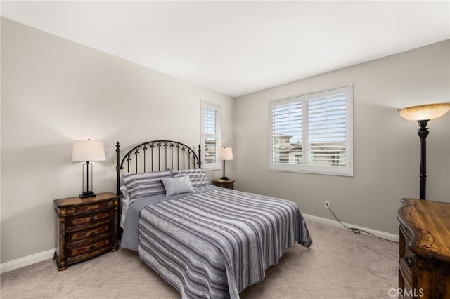 bedroom with light carpet and baseboards