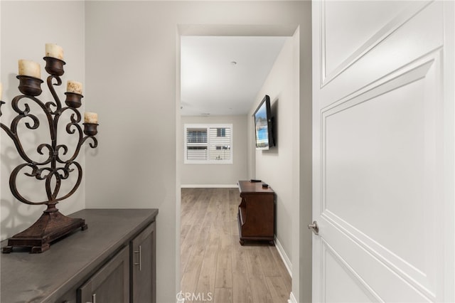 hall featuring light wood-style floors and baseboards