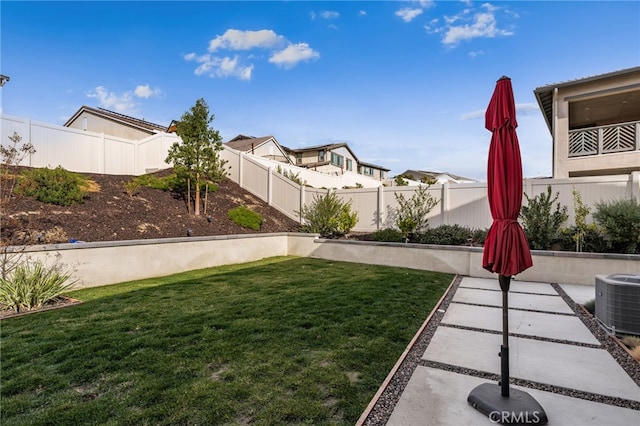 view of yard with a fenced backyard and central AC