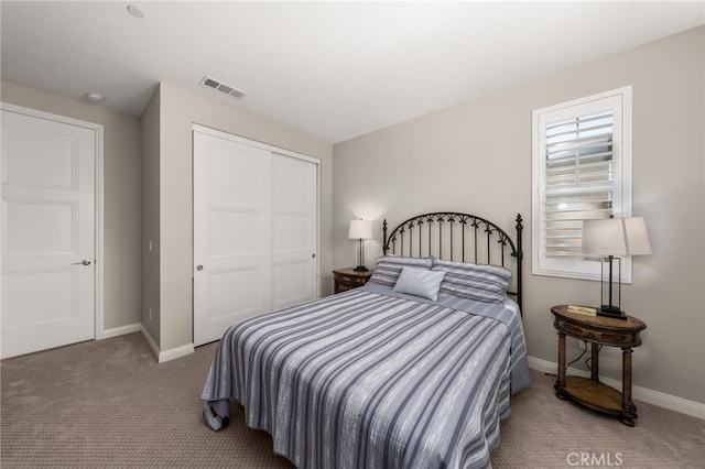 bedroom featuring carpet floors, baseboards, visible vents, and a closet