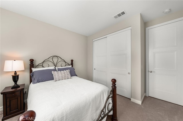 bedroom with a closet, carpet, visible vents, and baseboards