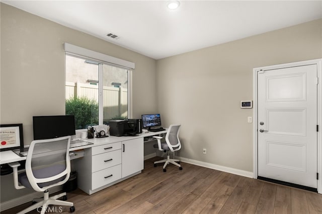 office with baseboards, visible vents, and wood finished floors