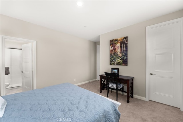 bedroom featuring light carpet, baseboards, and ensuite bathroom