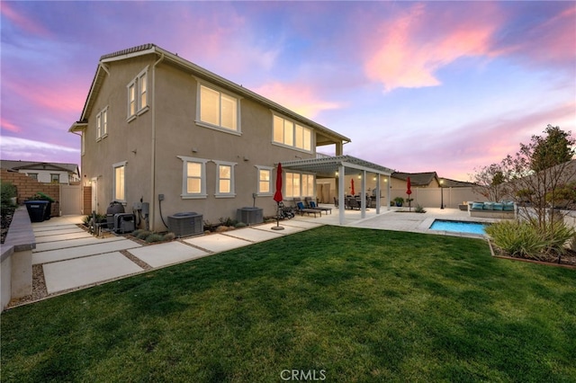 back of house at dusk featuring a fenced in pool, stucco siding, a lawn, a patio area, and a fenced backyard