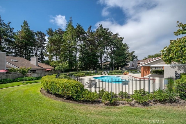 view of pool with a patio and a lawn