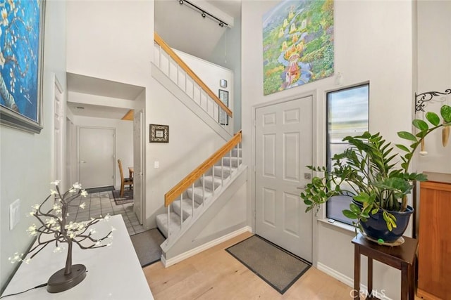 entrance foyer with light hardwood / wood-style floors and a high ceiling