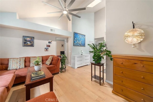 living room with ceiling fan, high vaulted ceiling, and light wood-type flooring