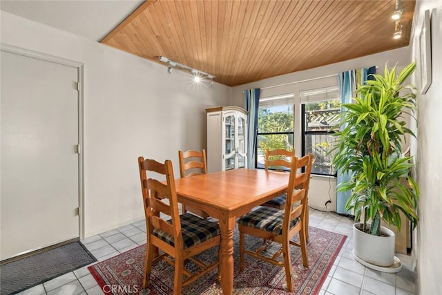 dining space with light tile patterned floors and wooden ceiling