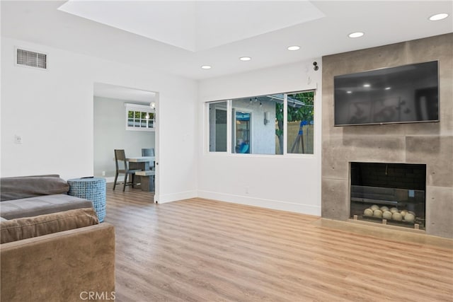 living room featuring hardwood / wood-style floors and a tile fireplace