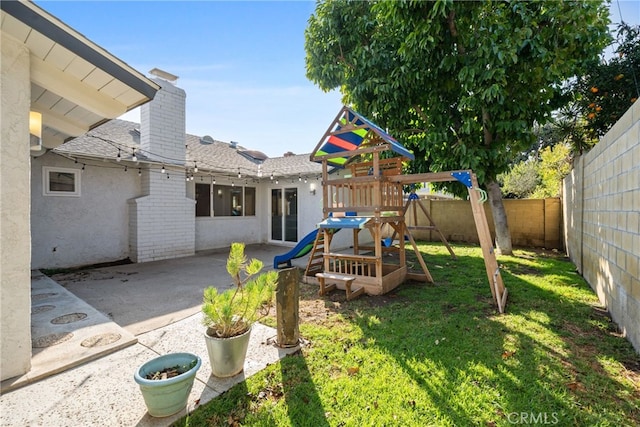 view of jungle gym featuring a patio area and a lawn