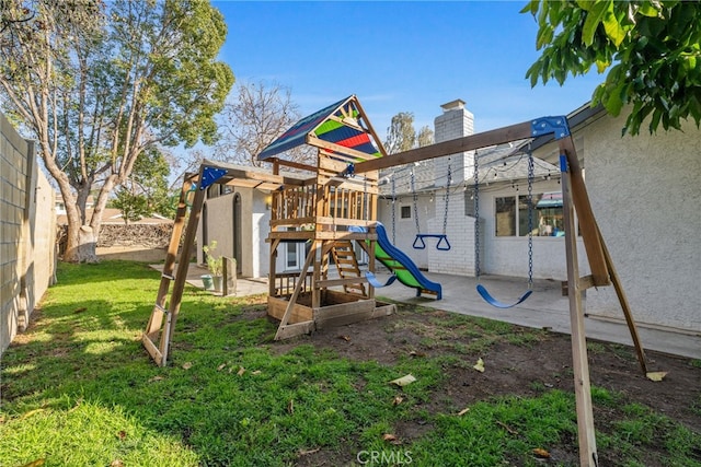 view of play area featuring a lawn and a patio