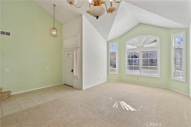 interior space with light carpet, a healthy amount of sunlight, vaulted ceiling, and a chandelier