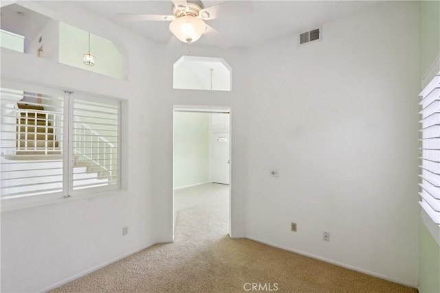 carpeted spare room featuring ceiling fan