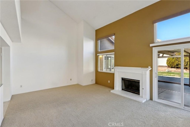 unfurnished living room with light carpet and high vaulted ceiling