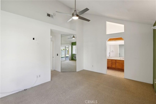 carpeted spare room featuring high vaulted ceiling and ceiling fan