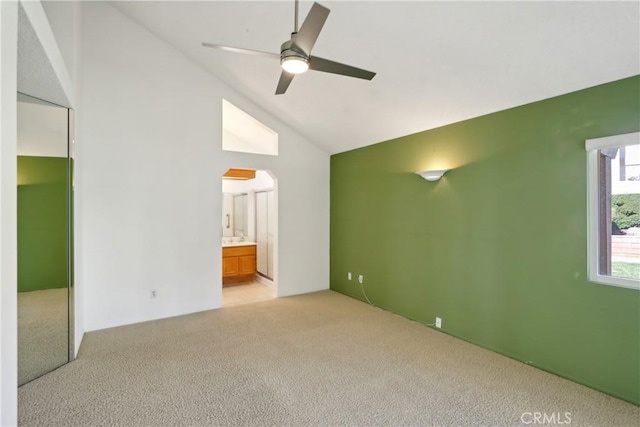 empty room with light carpet, vaulted ceiling, and ceiling fan