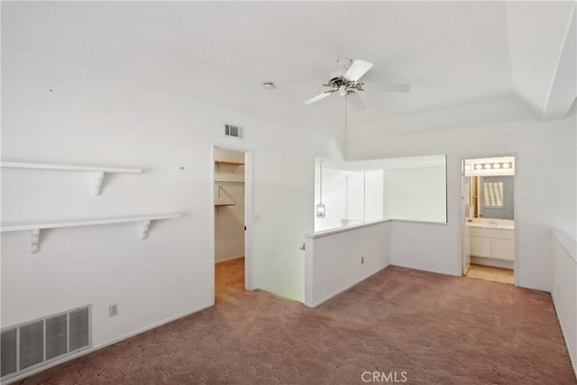 unfurnished bedroom featuring a walk in closet, connected bathroom, a closet, and carpet