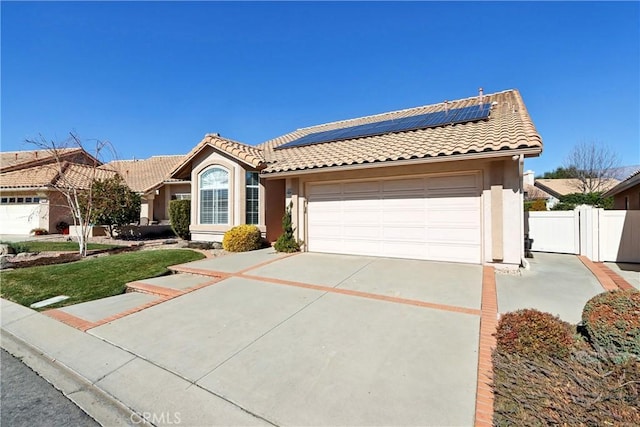 view of front of property featuring a garage and solar panels