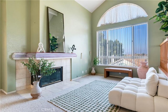 carpeted living room with a fireplace, vaulted ceiling, and plenty of natural light