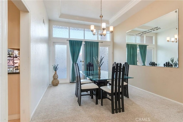 dining area featuring ornamental molding, carpet flooring, a raised ceiling, and a notable chandelier