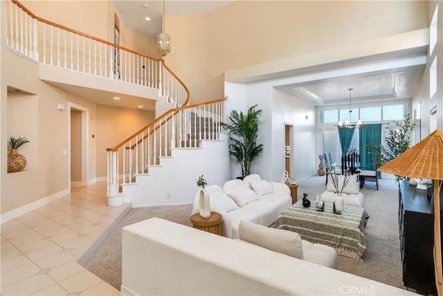 living room featuring a tray ceiling, a chandelier, and a high ceiling