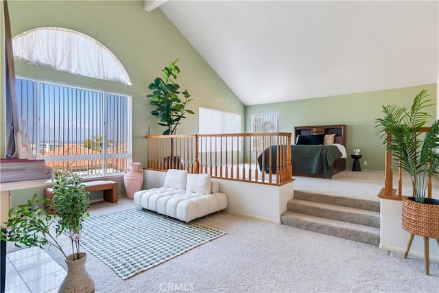 carpeted bedroom with multiple windows, high vaulted ceiling, and beamed ceiling