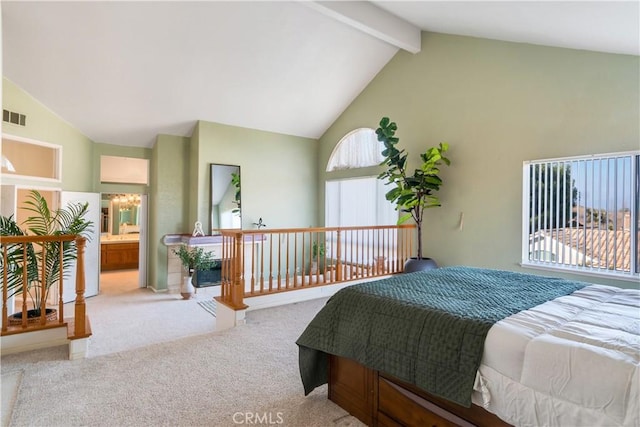 carpeted bedroom featuring multiple windows, ensuite bathroom, and lofted ceiling with beams