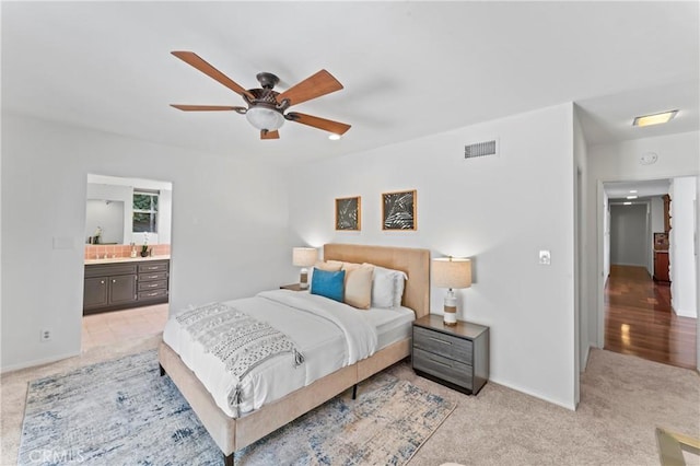 carpeted bedroom featuring ceiling fan and ensuite bath