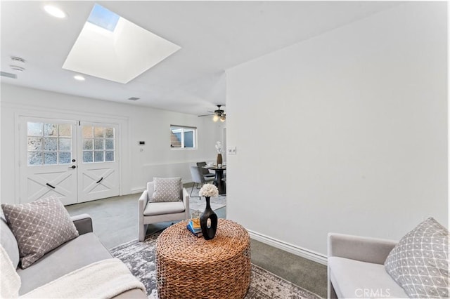 carpeted living room featuring a skylight