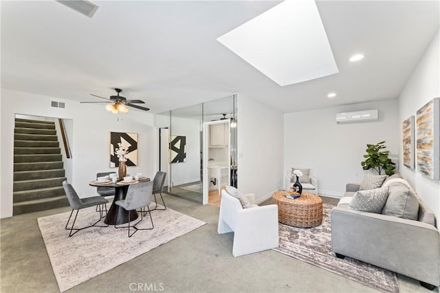 living room featuring a wall mounted AC, ceiling fan, and a skylight