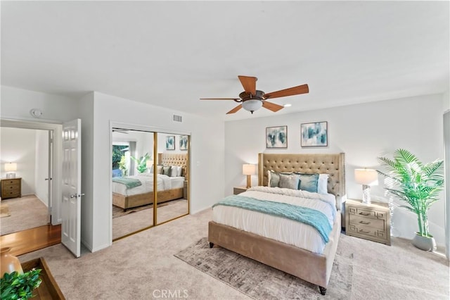 bedroom featuring ceiling fan, a closet, and light carpet