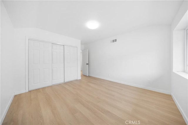 unfurnished bedroom with a closet and light hardwood / wood-style flooring