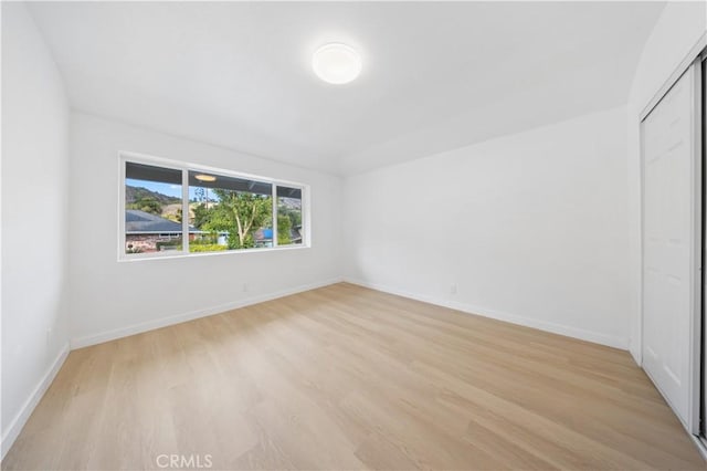 unfurnished bedroom with a closet and light wood-type flooring