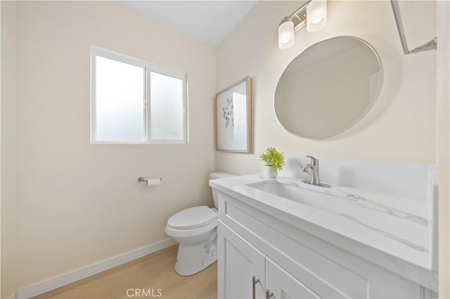 bathroom featuring vanity, hardwood / wood-style flooring, and toilet