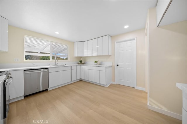 kitchen featuring white cabinetry, sink, light hardwood / wood-style flooring, and appliances with stainless steel finishes