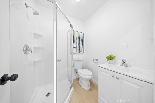 bathroom featuring walk in shower, vanity, toilet, and hardwood / wood-style floors