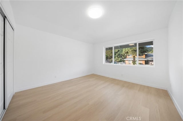 unfurnished bedroom with a closet and light hardwood / wood-style flooring