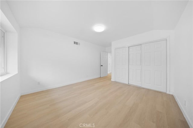 unfurnished bedroom featuring a closet and light hardwood / wood-style flooring