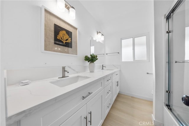 bathroom with vanity, combined bath / shower with glass door, and hardwood / wood-style floors