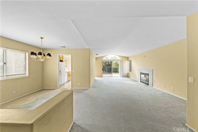 unfurnished living room with lofted ceiling, a chandelier, light carpet, and a fireplace