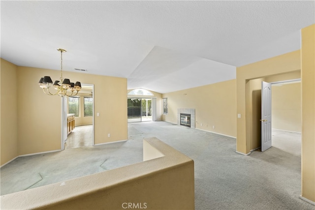 interior space featuring light carpet, a fireplace, an inviting chandelier, and vaulted ceiling