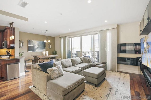 living room featuring dark wood-type flooring and a chandelier