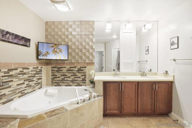 bathroom with tiled tub, vanity, and tile patterned floors