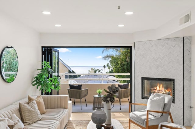 living area featuring hardwood / wood-style flooring and a large fireplace