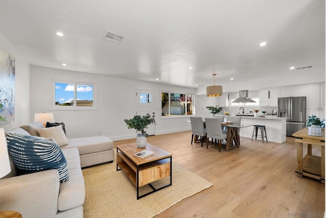 living room with sink and light hardwood / wood-style floors