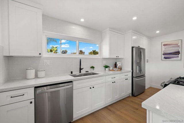 kitchen featuring white cabinetry, sink, backsplash, and stainless steel appliances