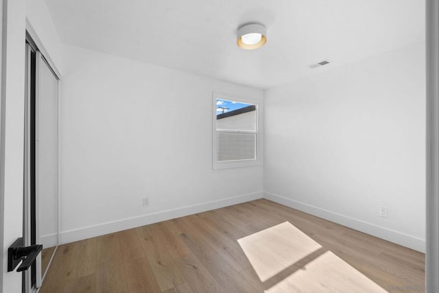 unfurnished bedroom featuring light hardwood / wood-style floors and a closet